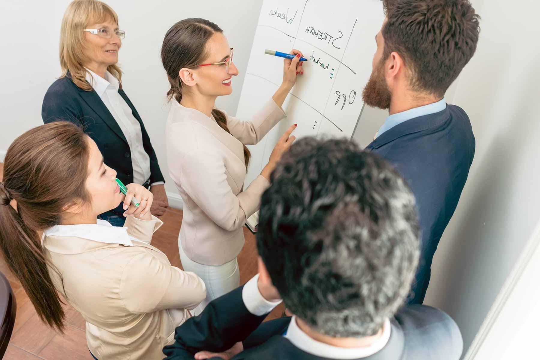 board members brainstorming on a large tablet